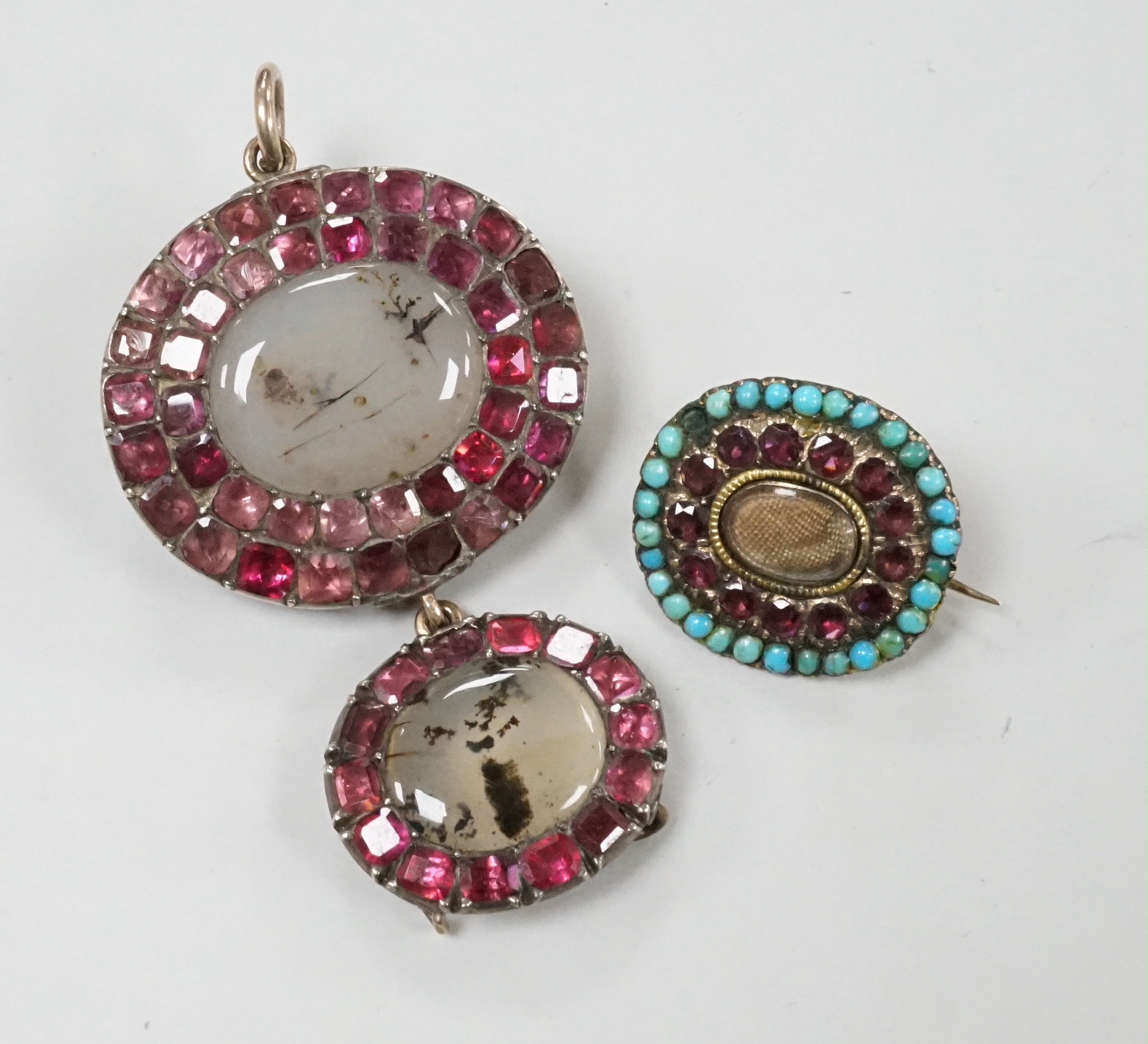 A Georgian white metal, foil backed garnet and moss agate set graduated drop brooch, 46mm and a small garner and turquoise set brooch.
